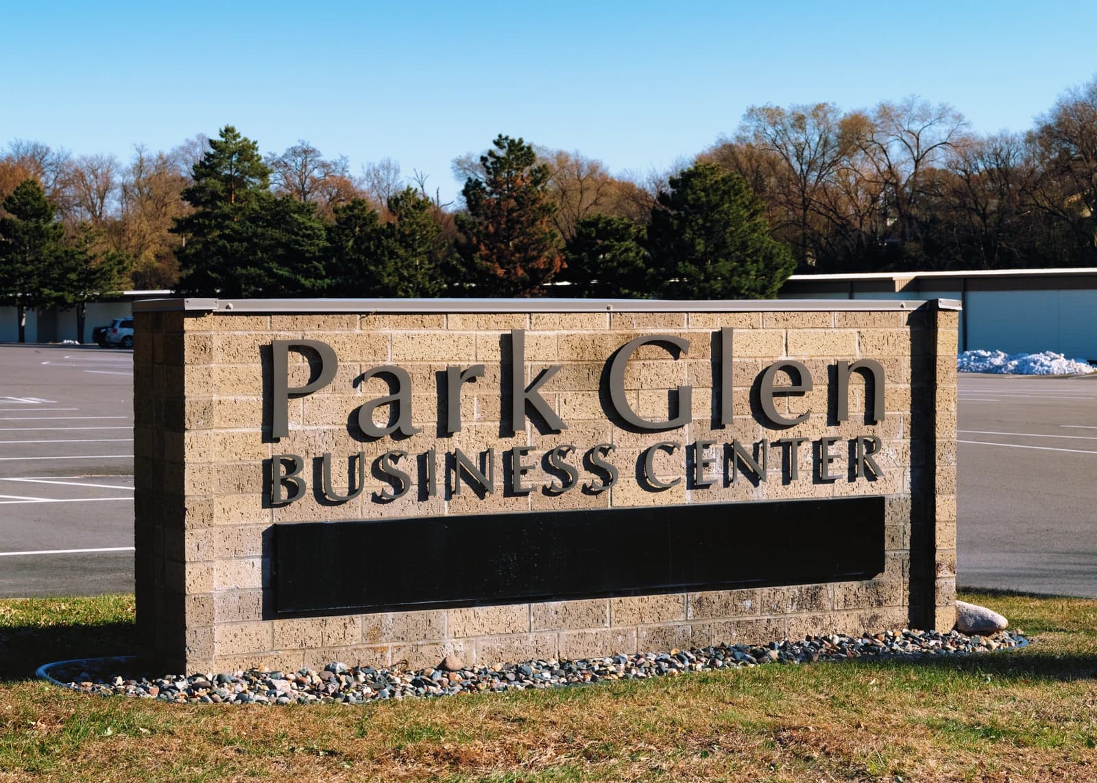 Brick sign with "Park Glen BUSINESS CENTER" in metal letters at entrance.