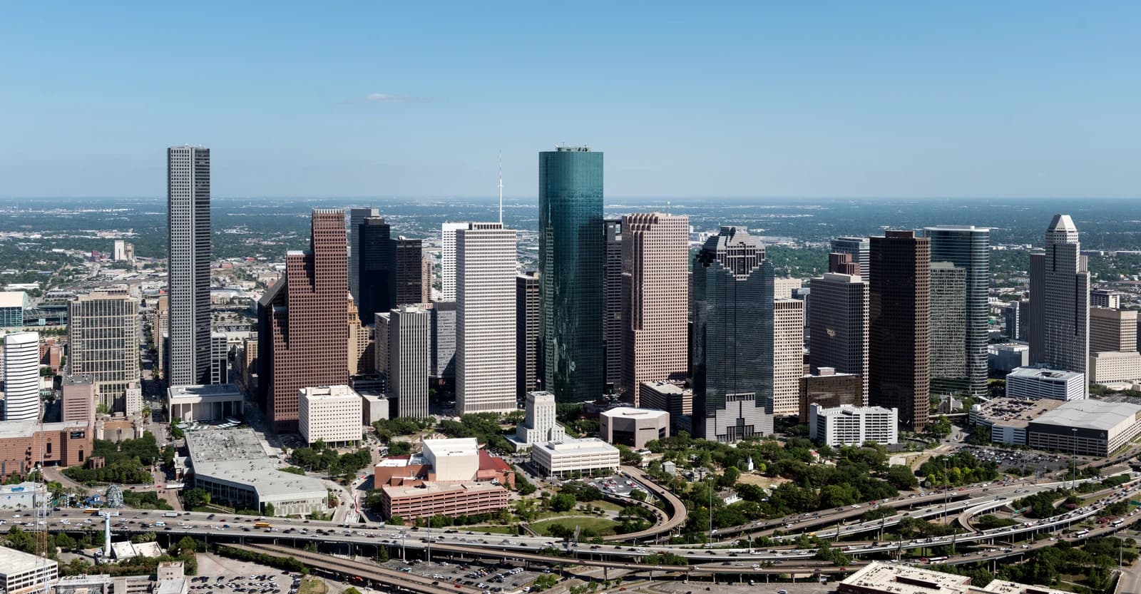 Aerial view of the downtown Houston skyline with tall buildings and highways.