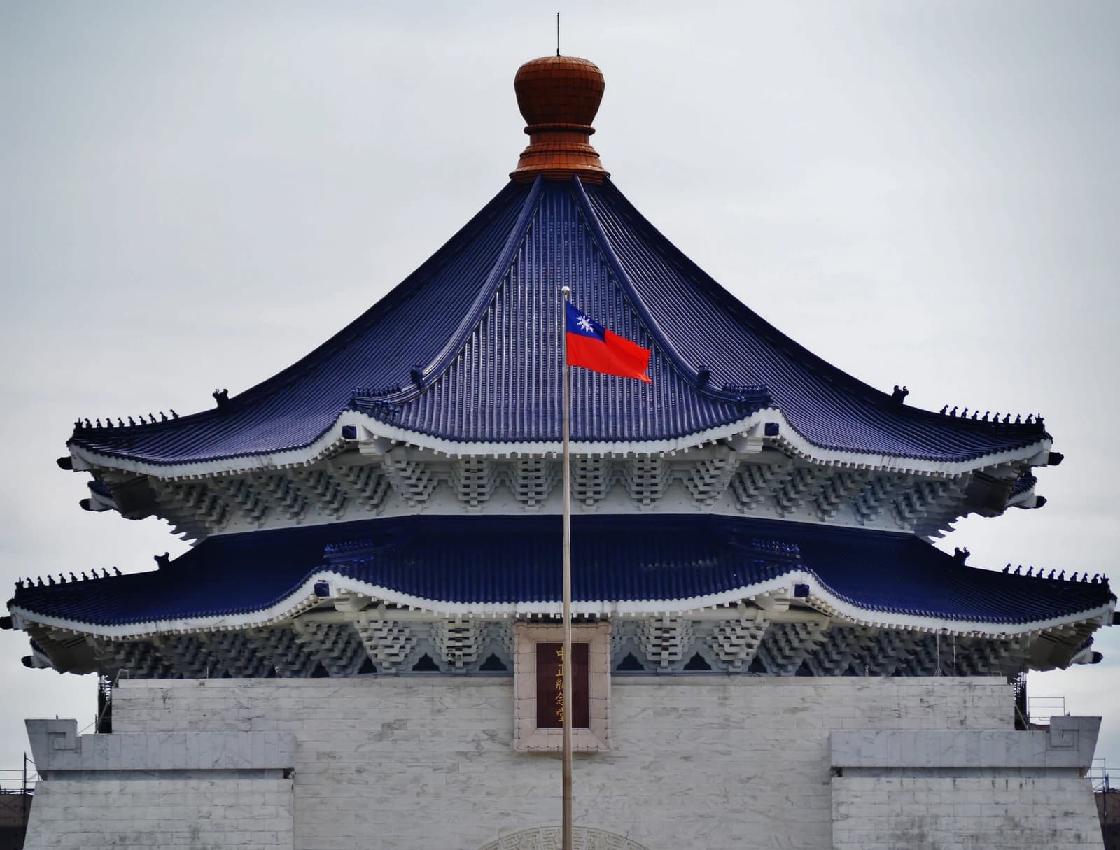Taiwanese flag waving in front of the Chiang Kai-shek Memorial Hall in Taipei, Taiwan.