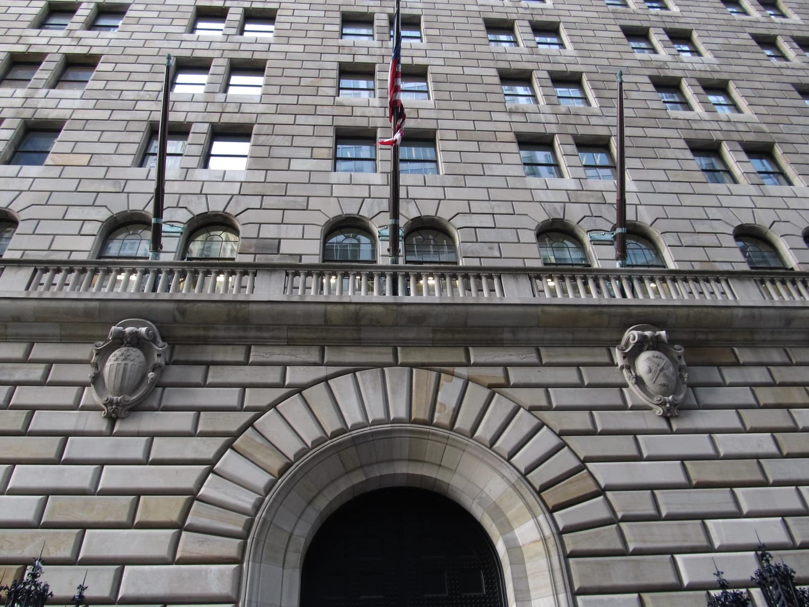 Federal Reserve Bank of New York building facade with arched entrance and windows.