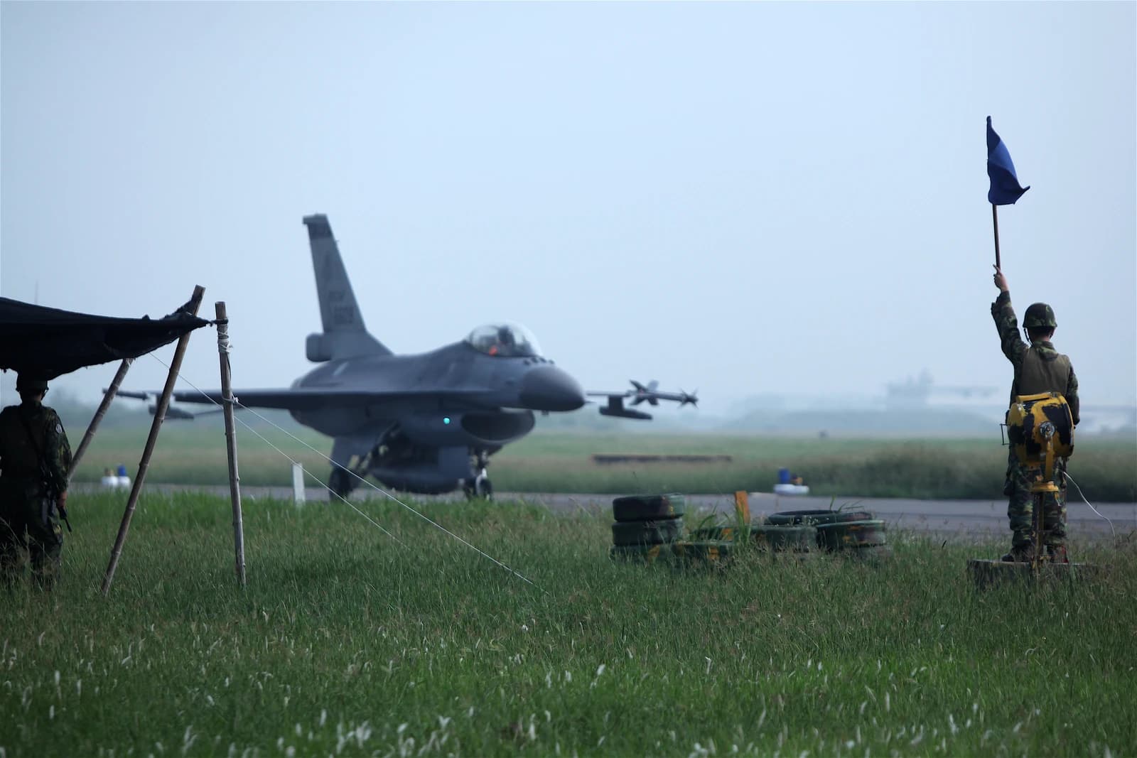 Military personnel and an F-16 fighter jet on an airfield in Taiwan.