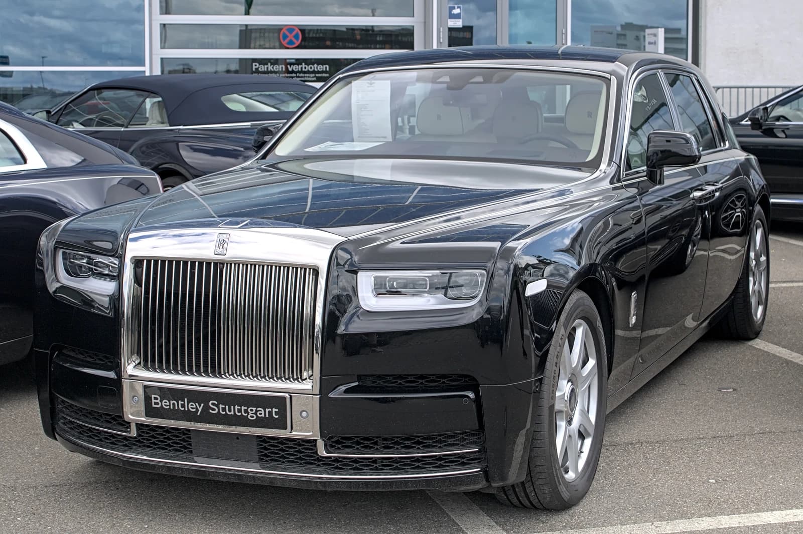 Black Rolls-Royce Phantom VIII Series I luxury car parked outside a dealership.