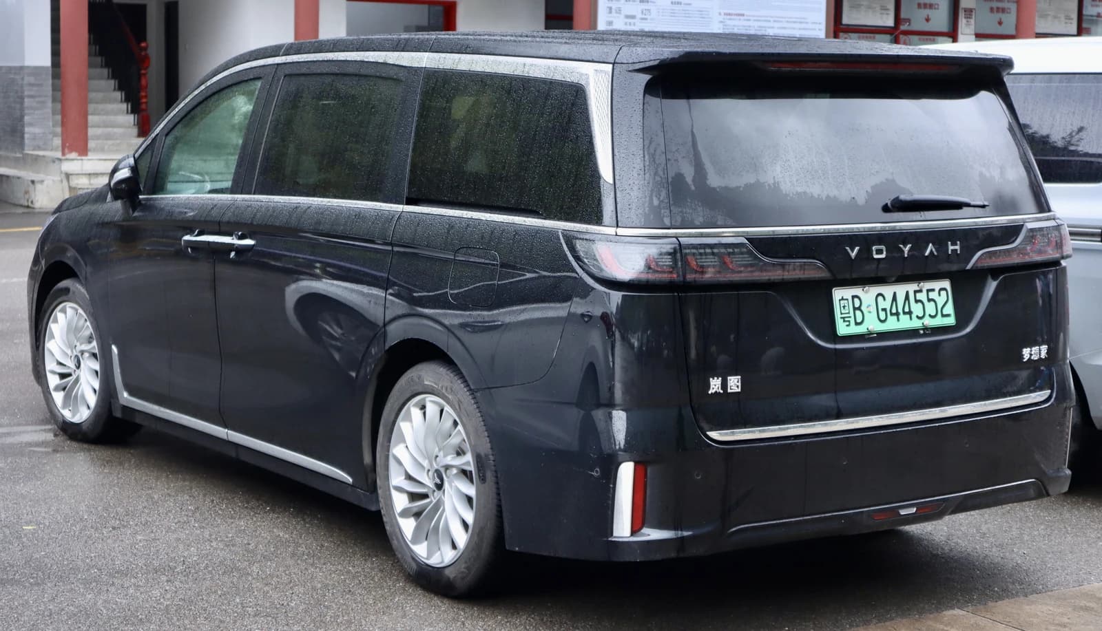 Rear view of a black Voyah Dreamer MPV parked on a wet surface.