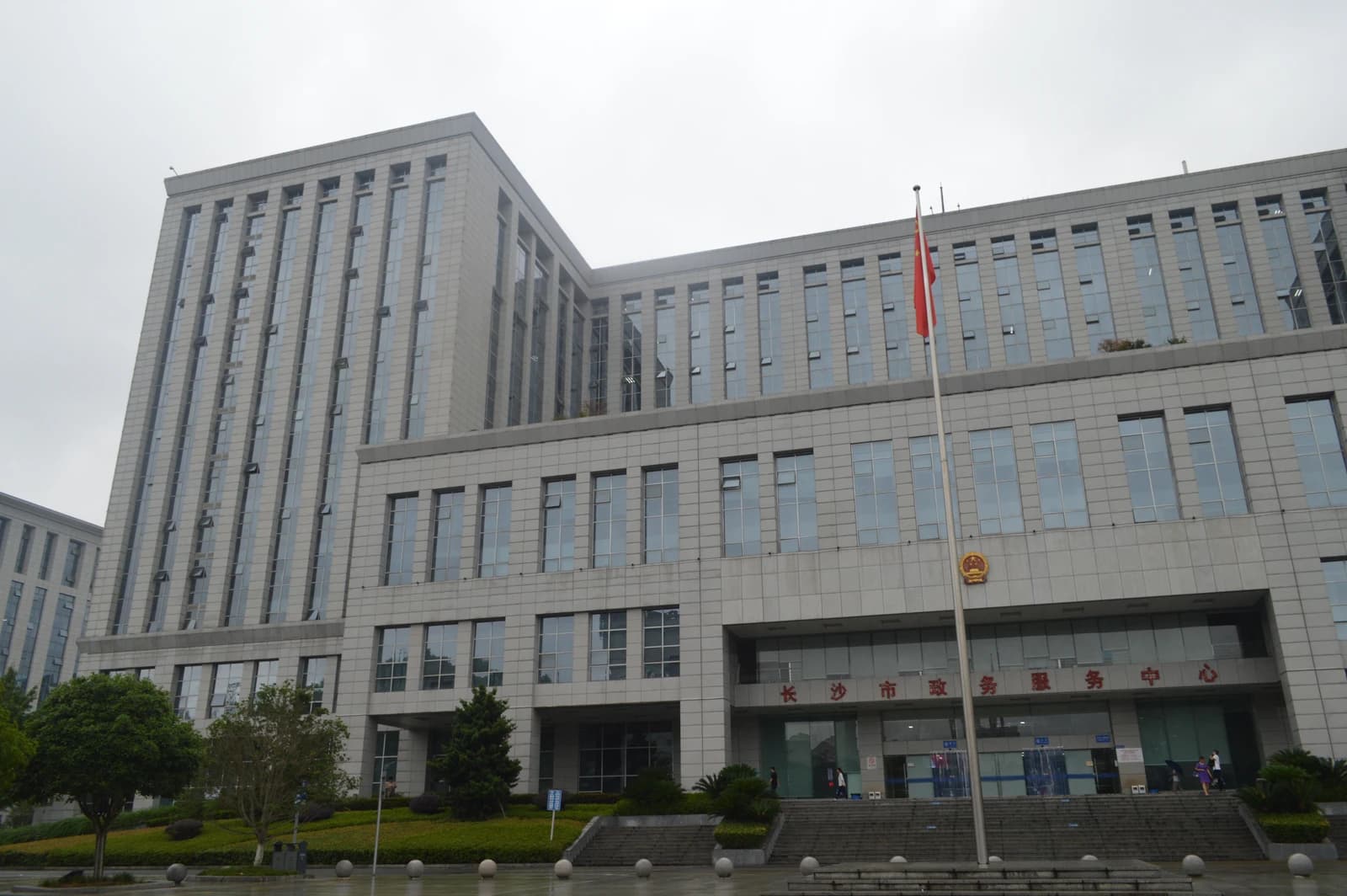 Changsha Municipal Government Affairs Service Center, a modern gray building under a cloudy sky.