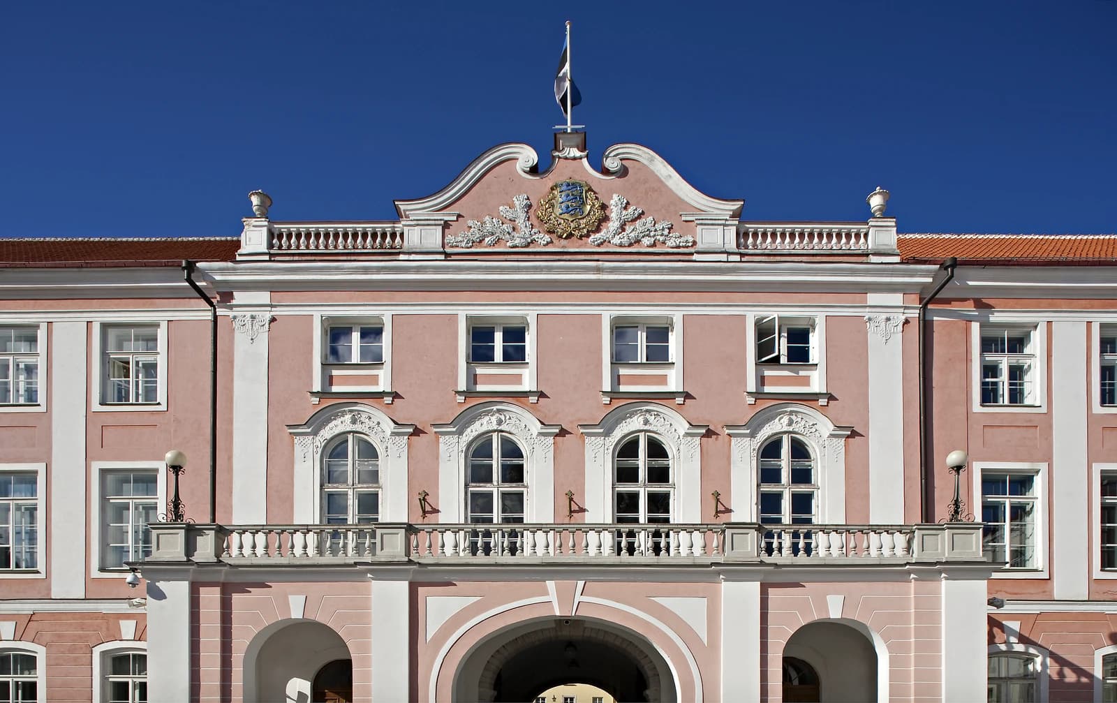 Building facade of the Estonian Parliament, with a flag flying above.