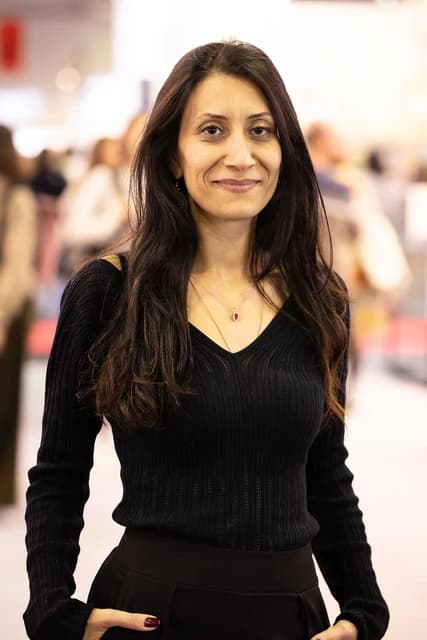 Dilek Mayatürk-Yücel stands at the Frankfurt Book Fair looking towards the camera.
