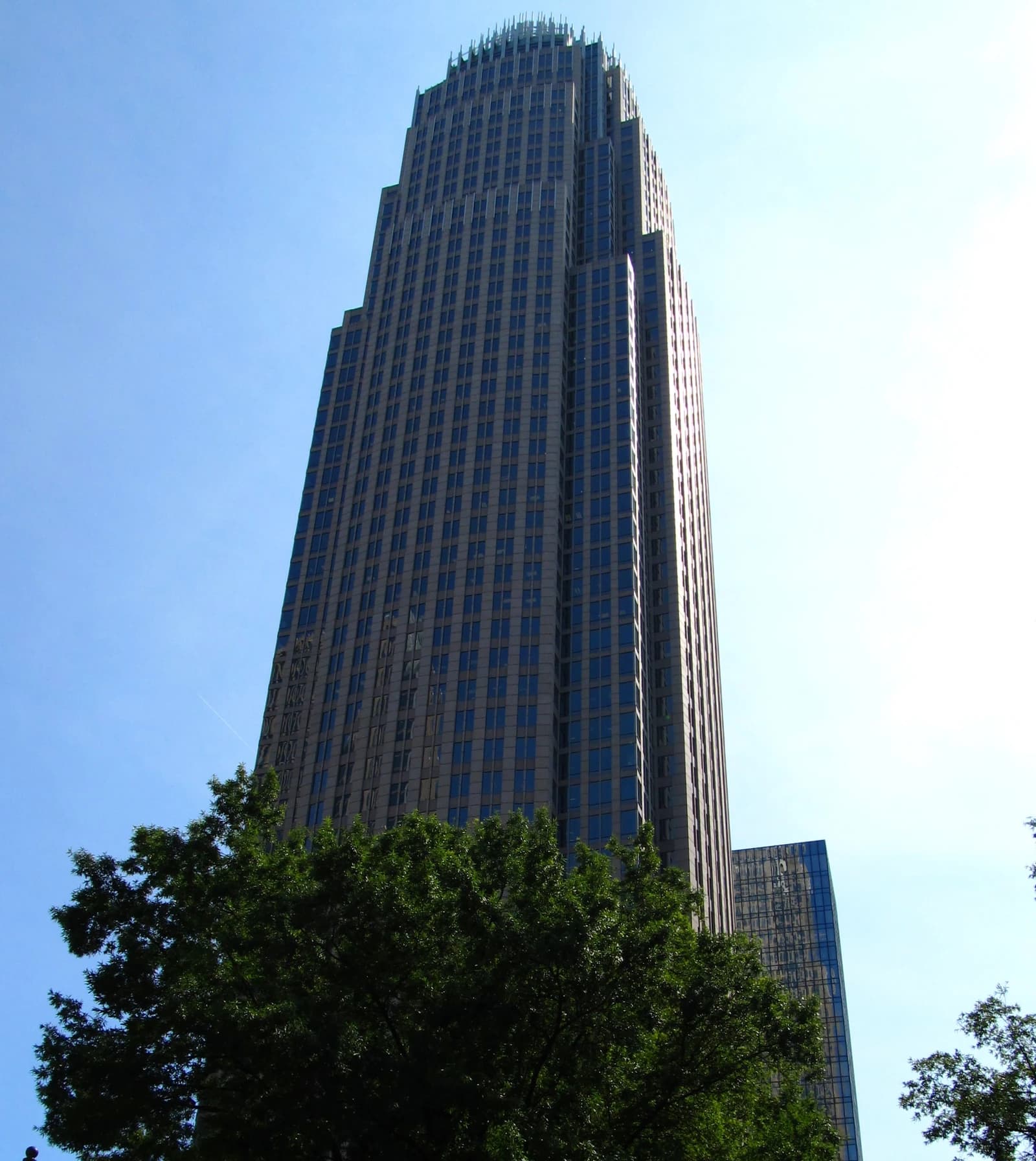 Bank of America Corporate Center, a tall skyscraper, against a blue sky.