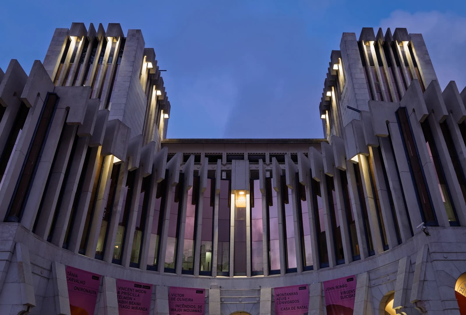 Upward view of the Caixa Geral de Depósitos headquarters building in Lisbon, Portugal at dusk.