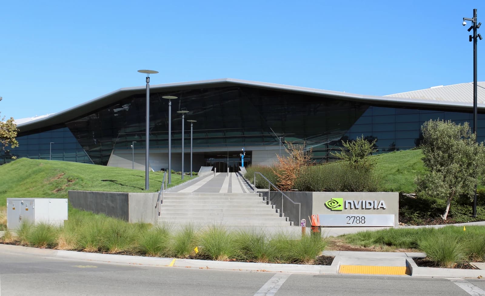 NVIDIA headquarters building, a large modern structure with dark windows and a prominent logo sign.