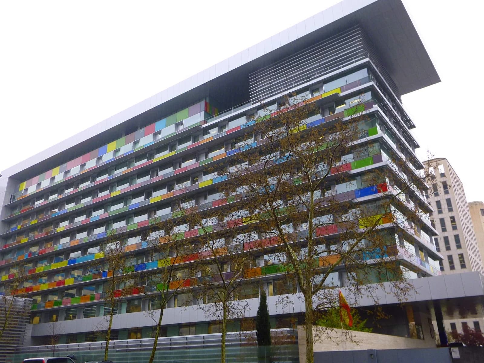 Exterior of the Instituto Nacional de Estadística building in Madrid with colorful panels.