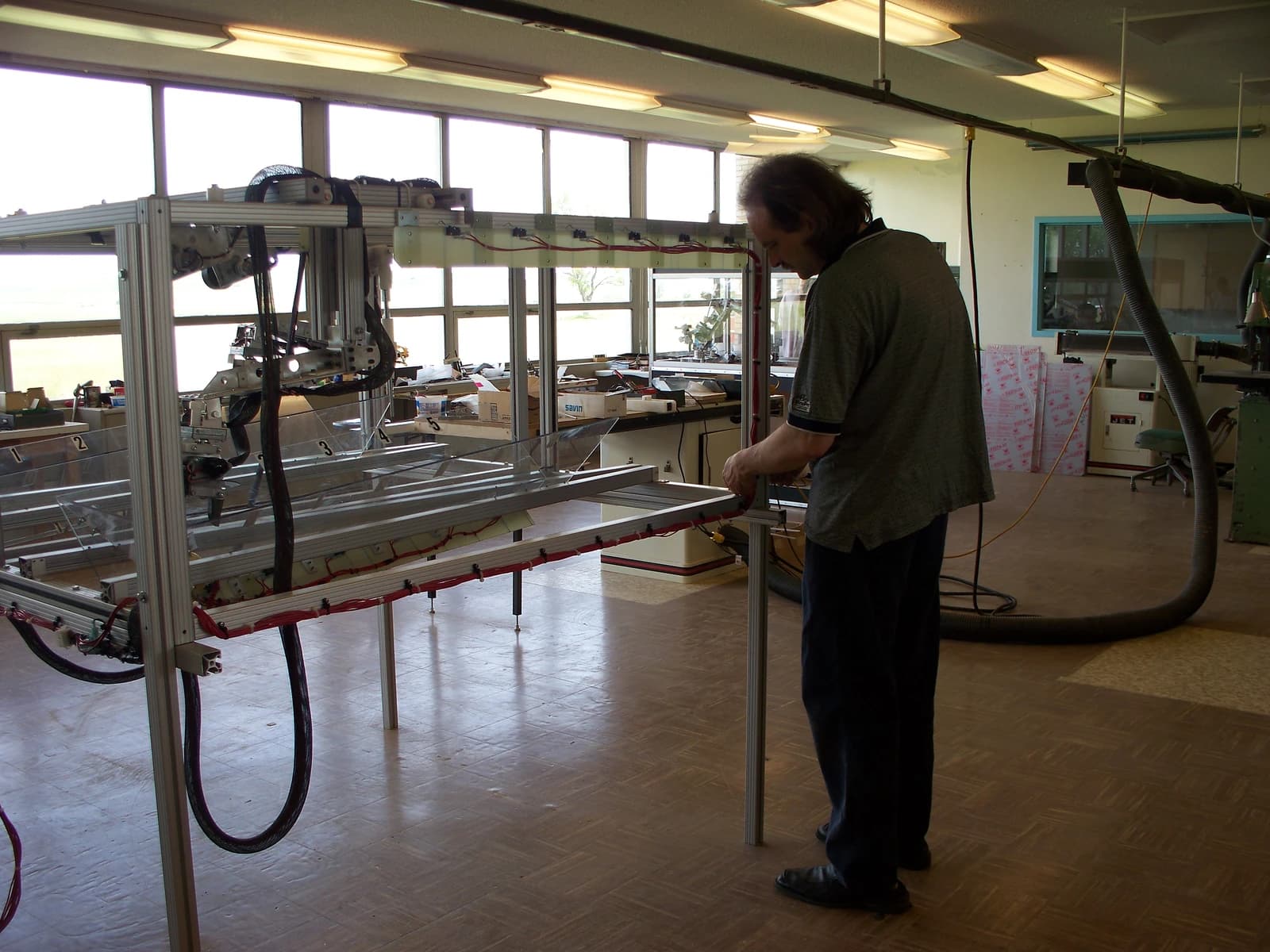 John Siegel works on a metal-framed robotic prototype in a brightly lit workshop.