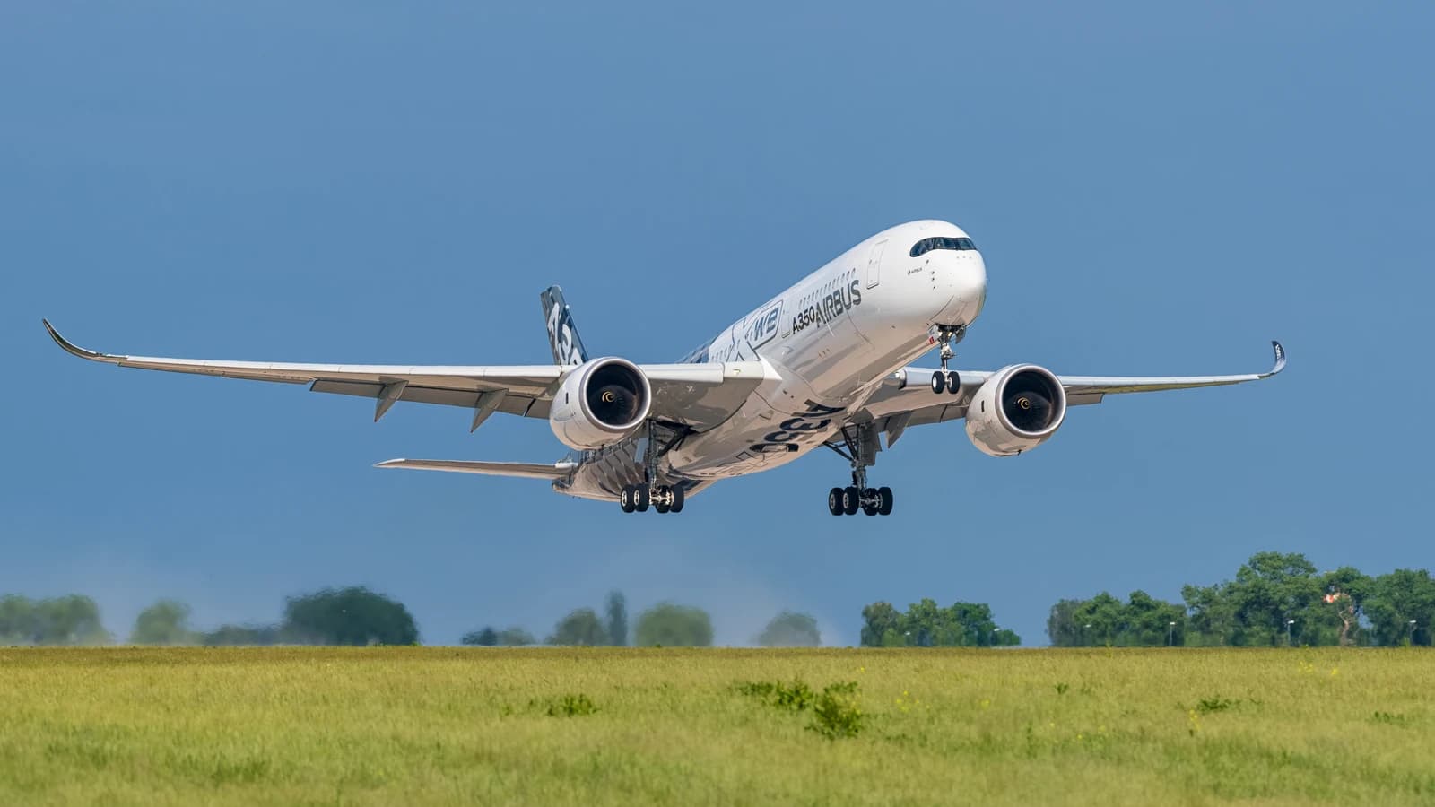 An Airbus A350-941 aircraft in white livery taking off with landing gear extended.