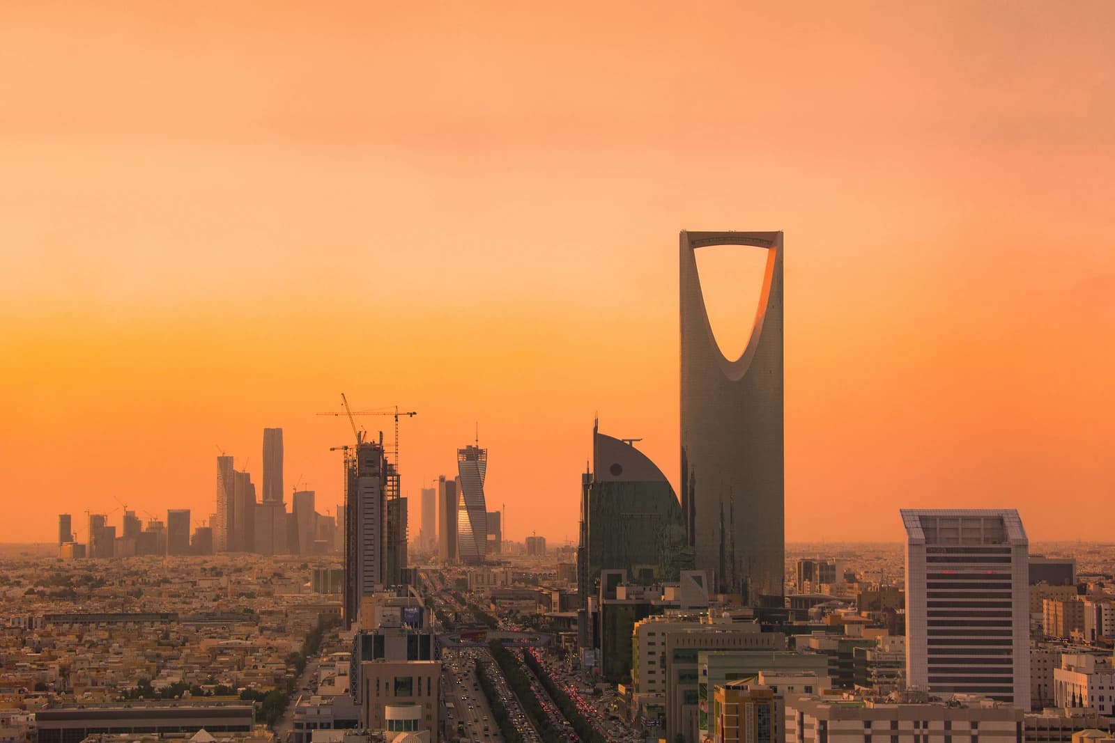 Skyline of Riyadh, Saudi Arabia, featuring modern skyscrapers at sunset.