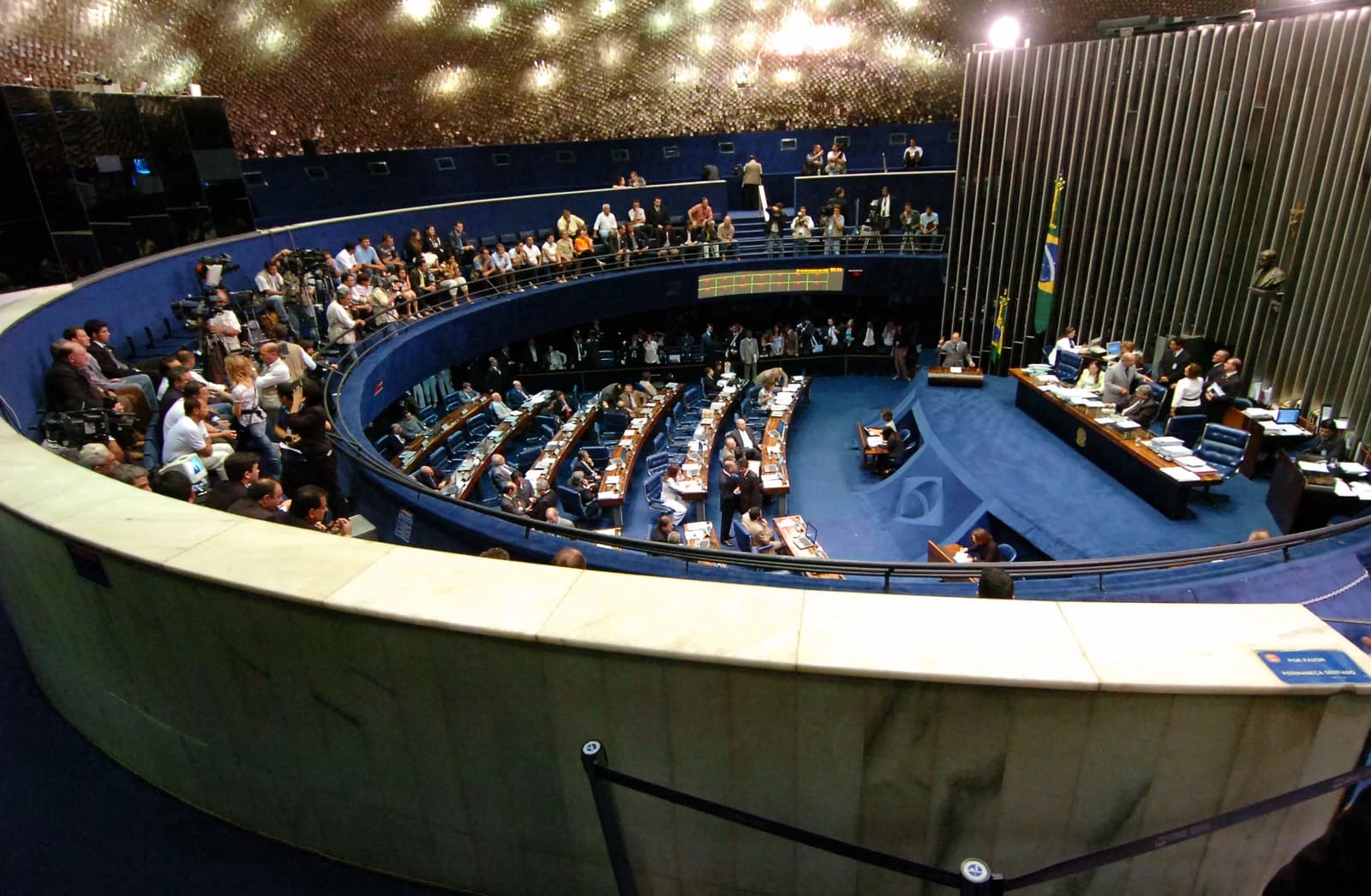 Plenary chamber of the Brazilian Senate with senators and staff during a session.