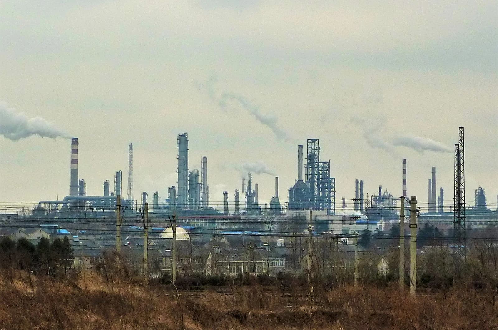 An industrial panorama in Ganjiaxiang showing numerous smokestacks and buildings under a cloudy sky.