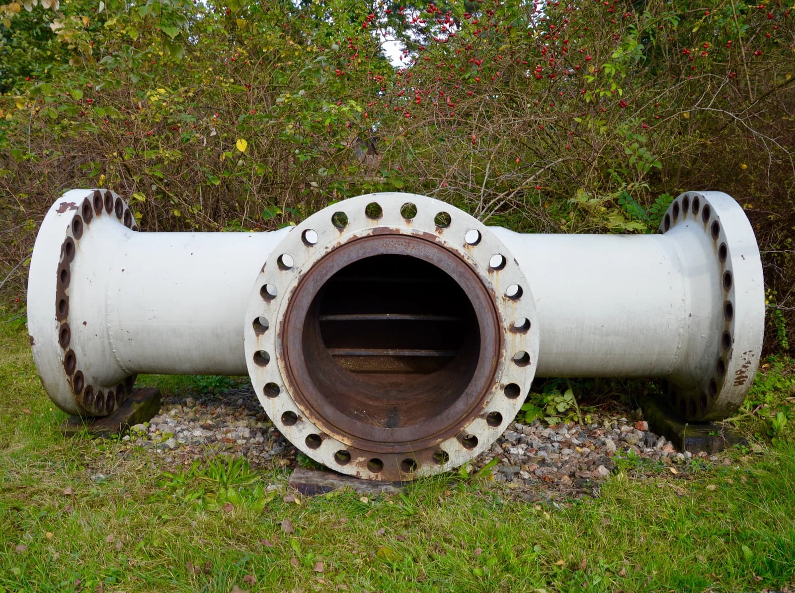 A T-section of a natural gas pipeline made of metal with flanges.