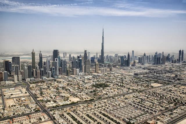 Aerial view of the Dubai skyline with the Burj Khalifa towering over other buildings.