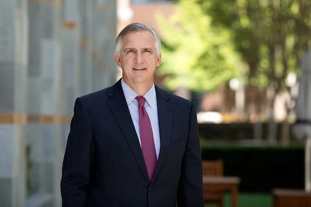 Robert A. Bradway, CEO of Amgen, posing for a portrait outdoors in a suit and tie.
