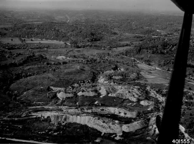 Aerial view of a large coal mine stripping operation with disturbed earth.