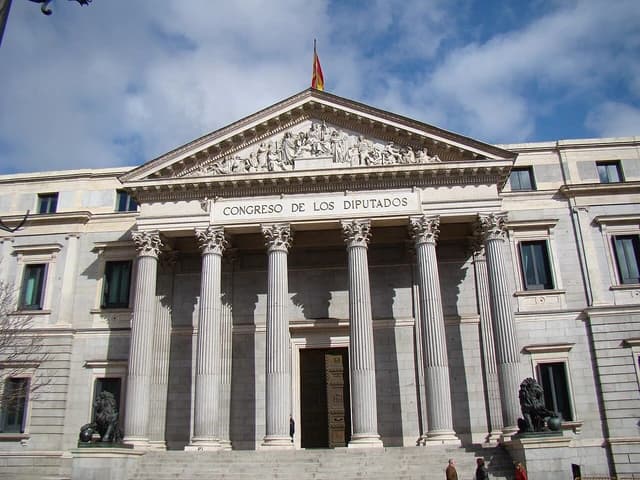 Exterior facade of the Palacio de las Cortes building with Corinthian columns and steps.