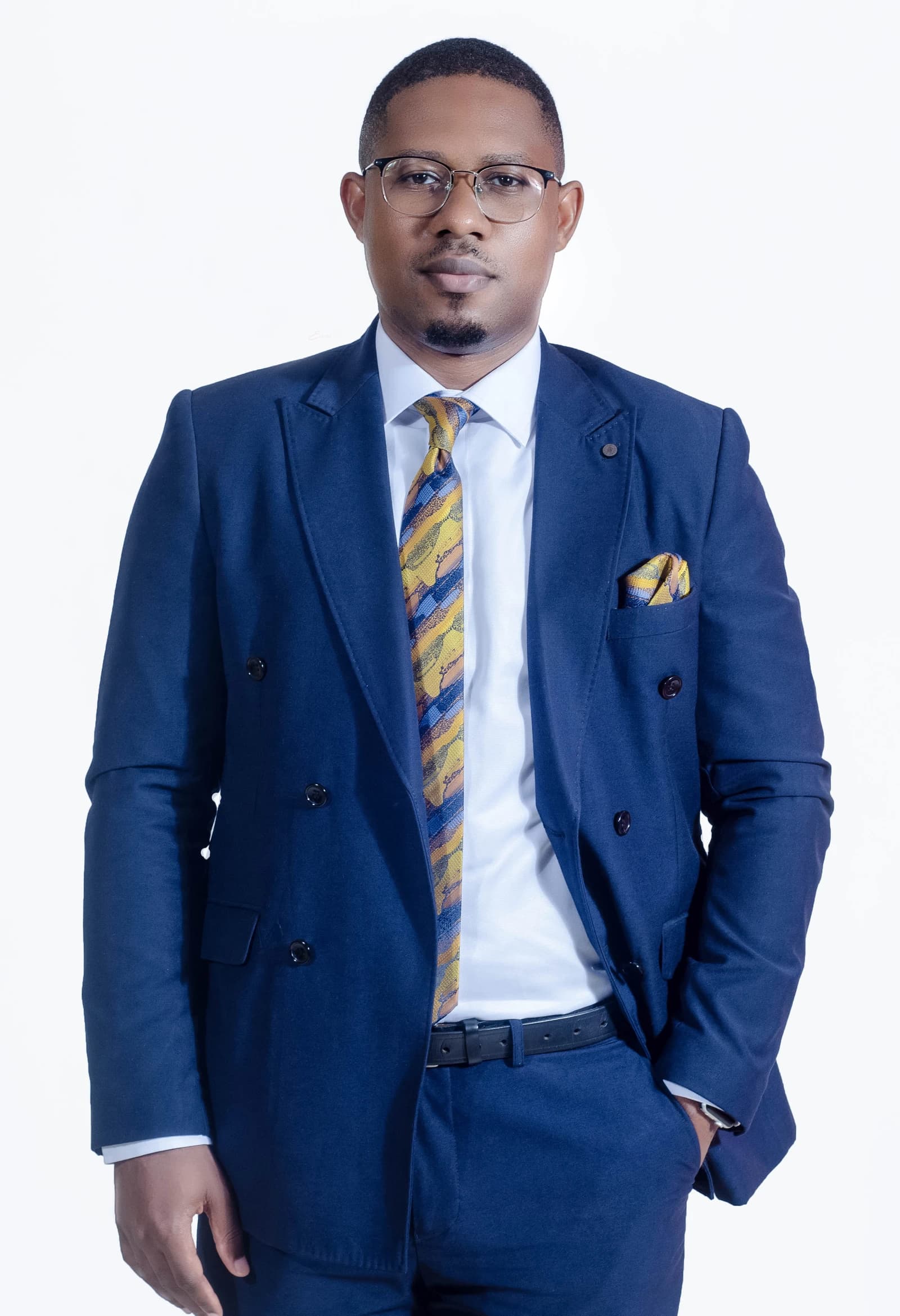 Pisso Nseke, a Cameroonian geopolitologist, stands looking forward in a suit.