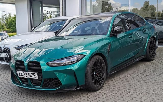 Green 2023 BMW M3 Competition xDrive Auto car parked outdoors.