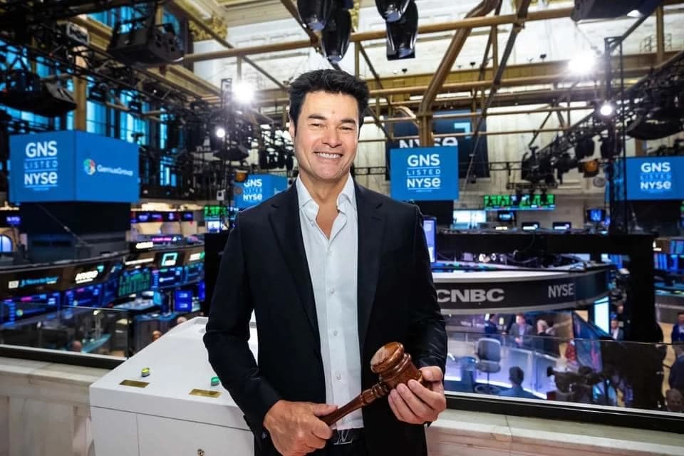 Roger holding a gavel on the trading floor of the New York Stock Exchange.