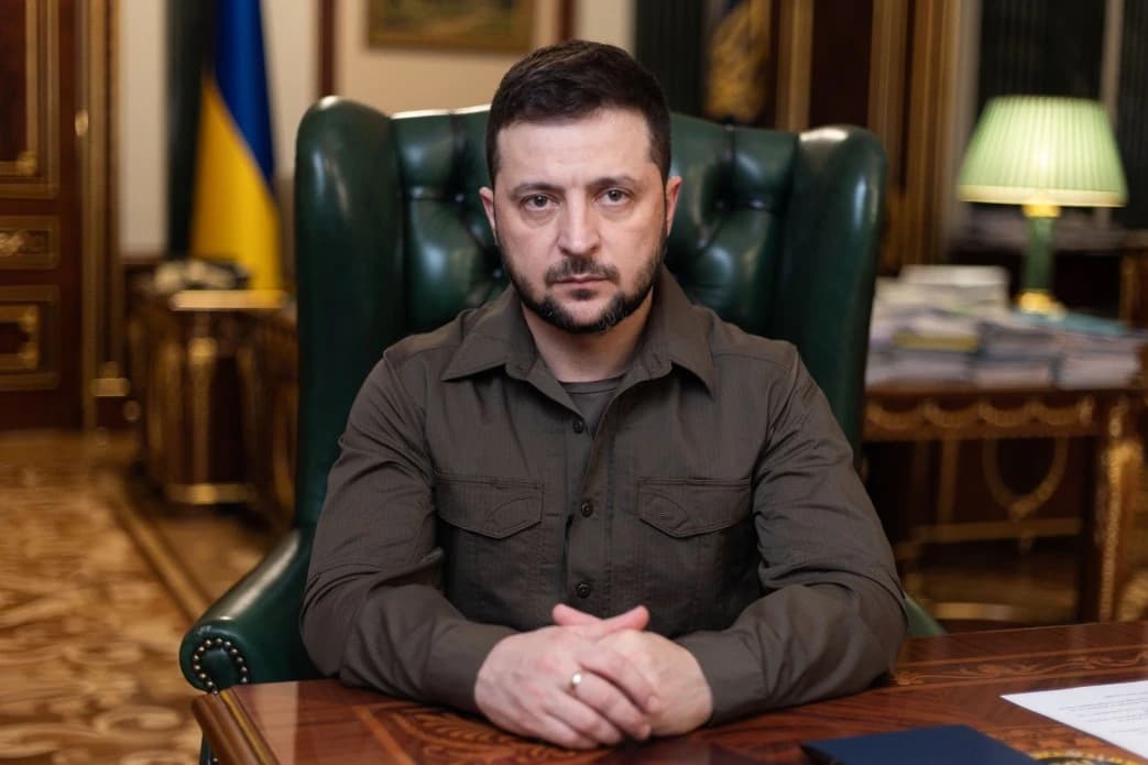 President Volodymyr Zelenskyy of Ukraine sits at a desk, looking forward.