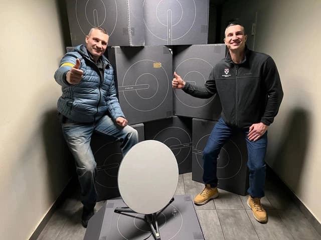 Wladimir and Vitali Klitschko pose with a Starlink user terminal and boxes.