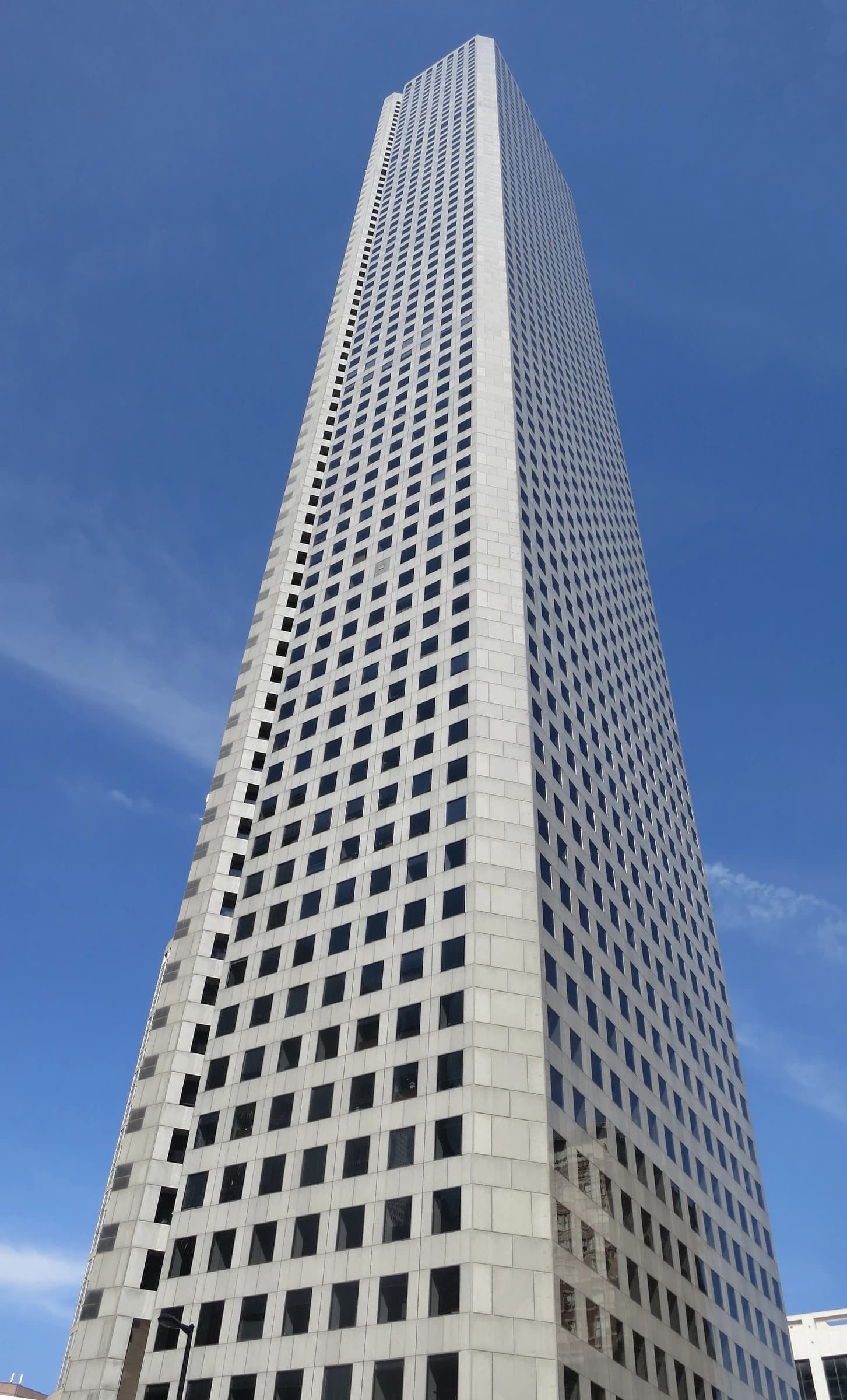 JPMorgan Chase Tower, a tall building with many square windows, against a blue sky.