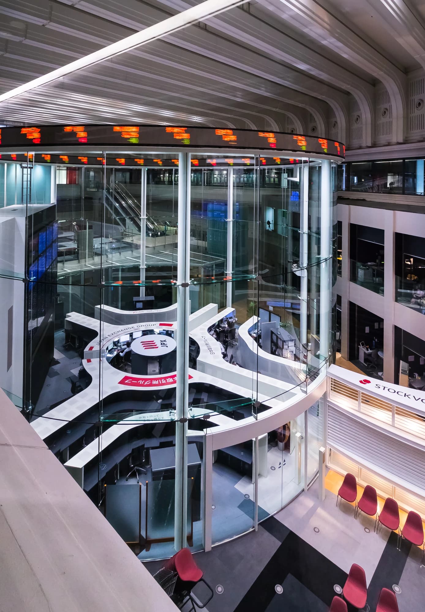 Interior of the Tokyo Stock Exchange main trading room with a curved digital ticker board.