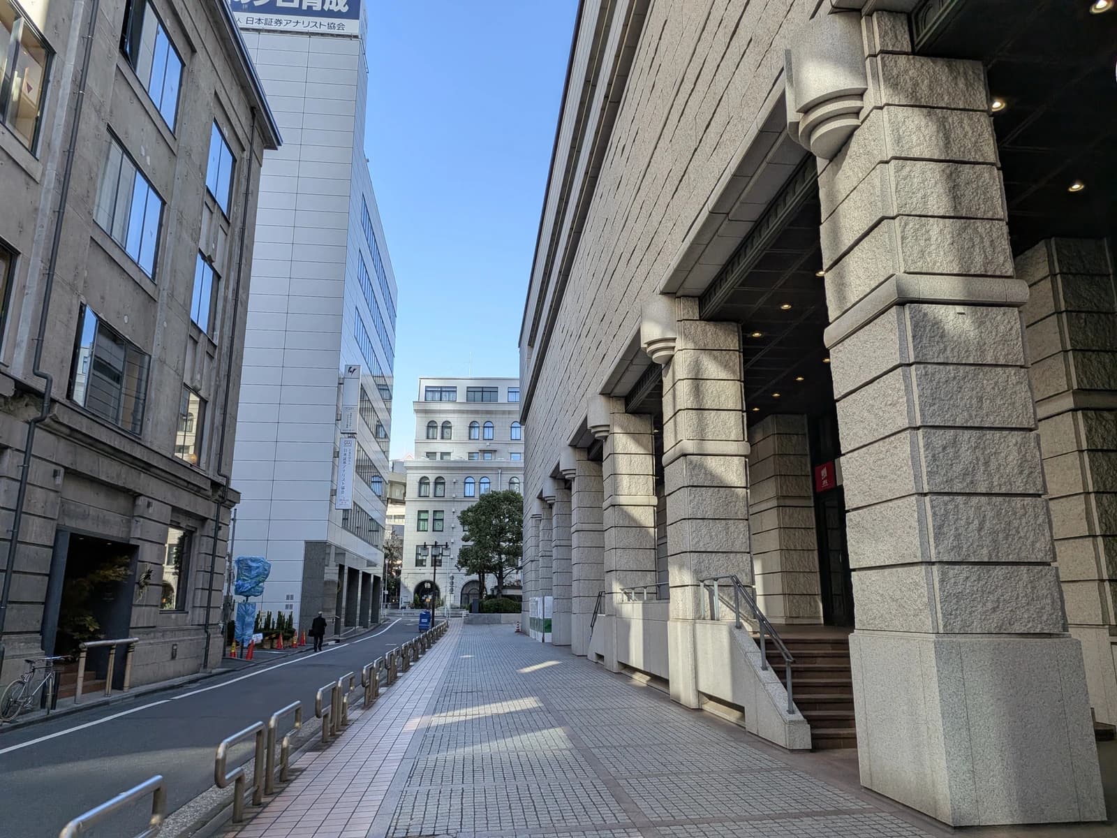 Street scene outside the Tokyo Stock Exchange building on a clear day.