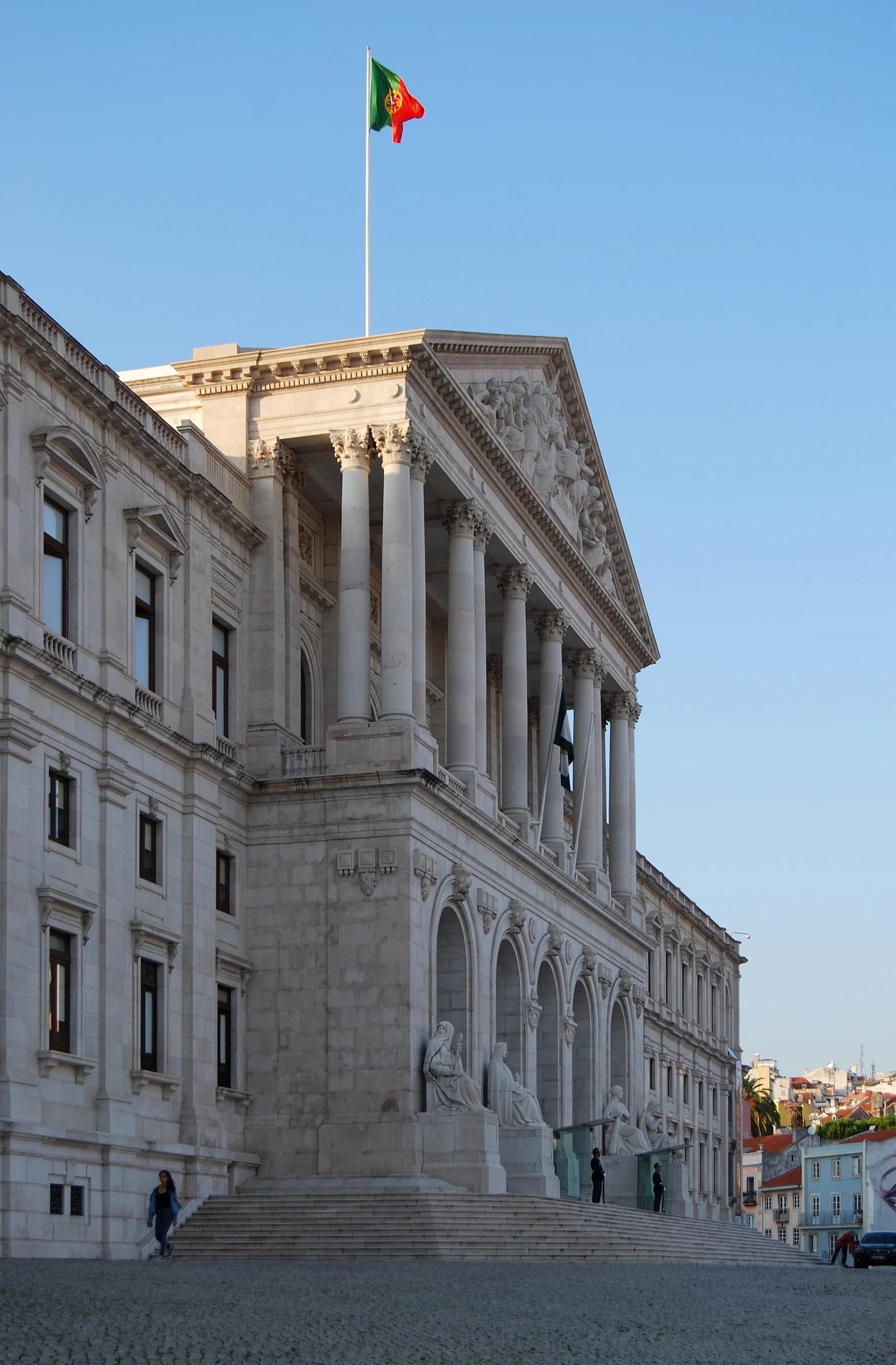 Exterior view of Palácio de São Bento, a large neoclassical building with a Portuguese flag.