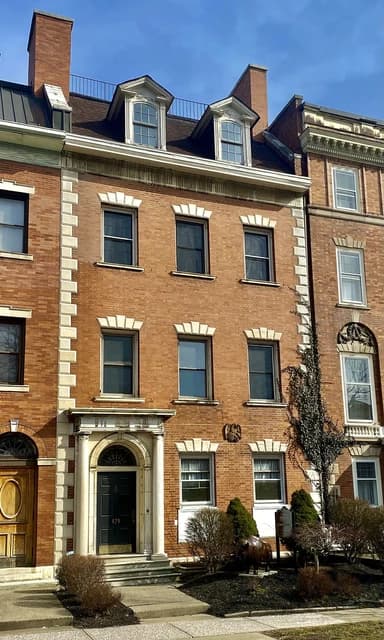 The Harlow C. Curtiss House, a historic brick building with many windows.