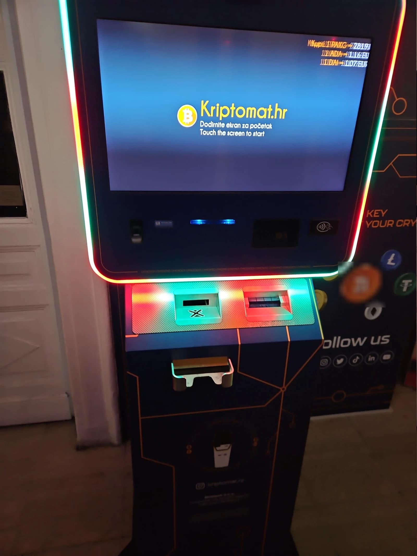 Cryptocurrency ATM with a screen displaying 'Touch the screen to start'.