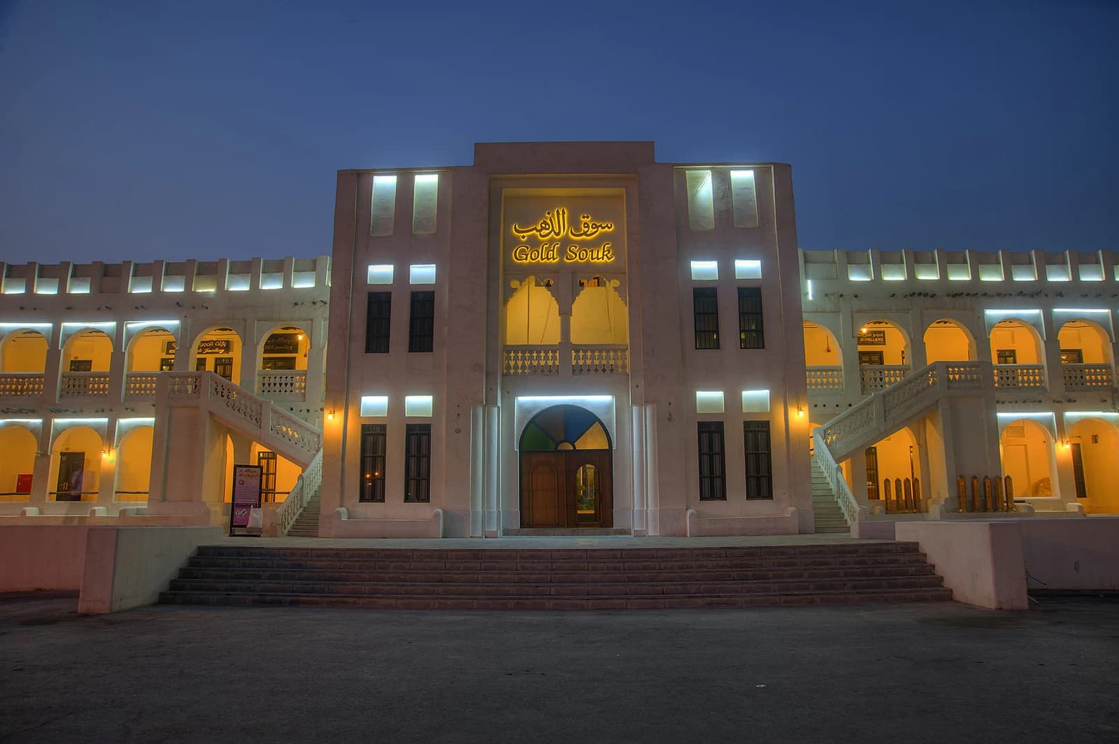 Exterior of the Gold Souk building with illuminated signage at dusk.
