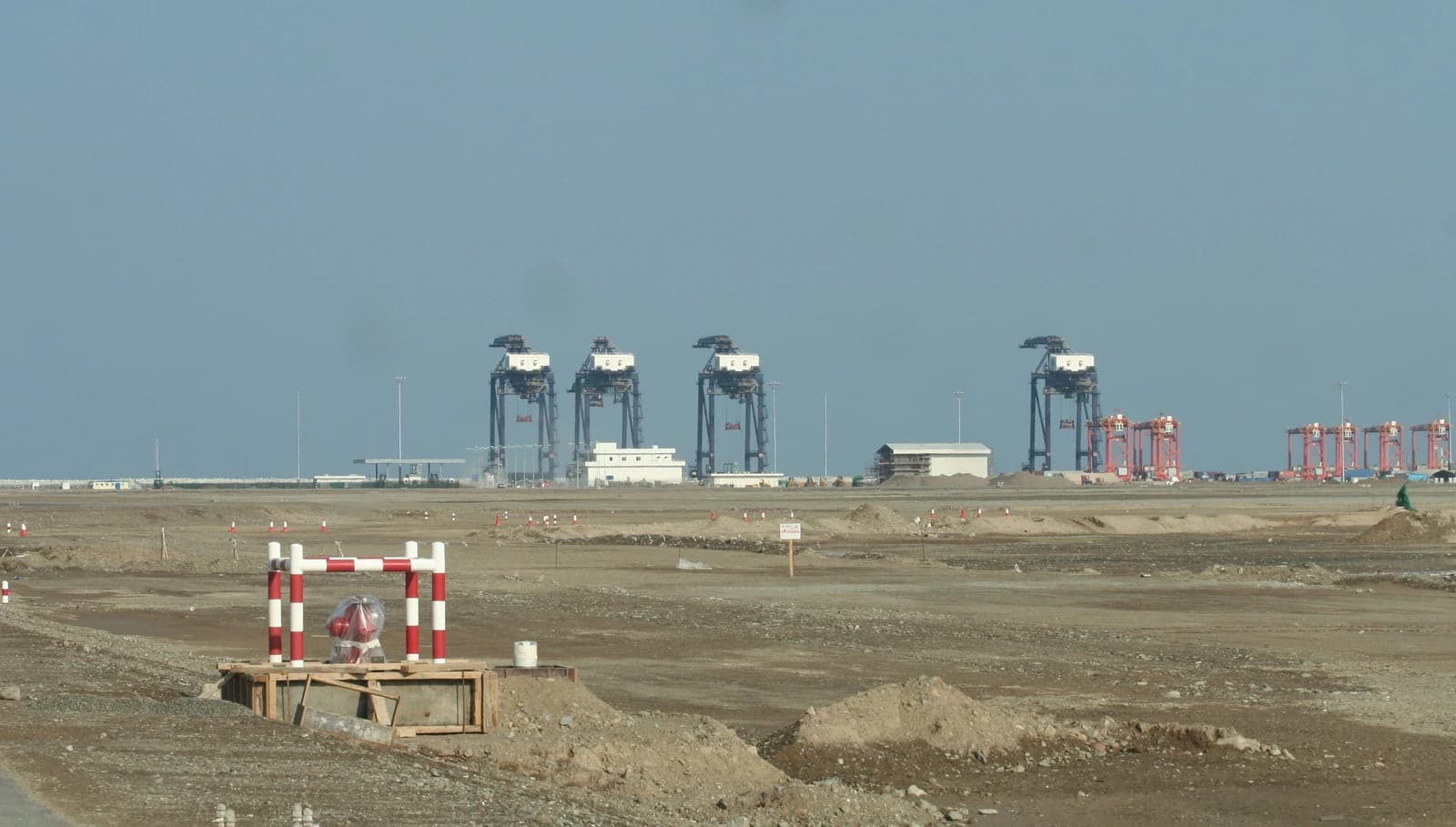 Port of Sohar in Oman with multiple large container cranes in the distance.