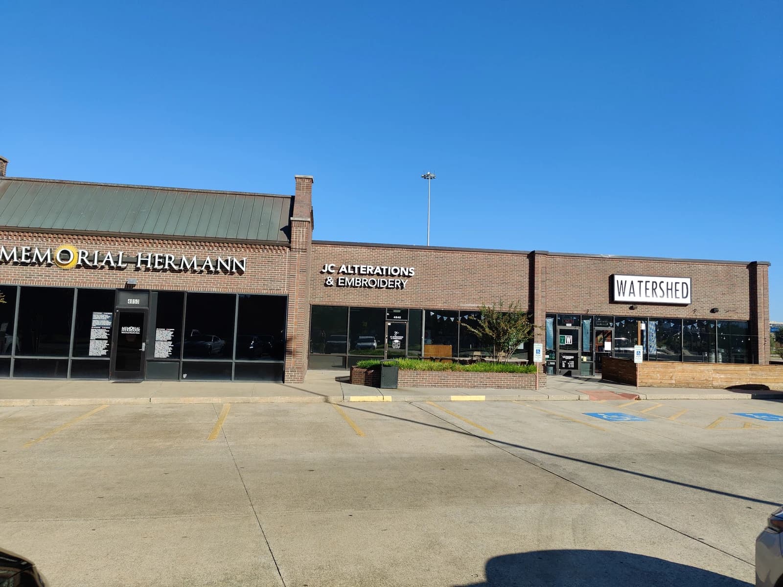 Exterior view of Meyer Park Shopping Center with various retail storefronts.