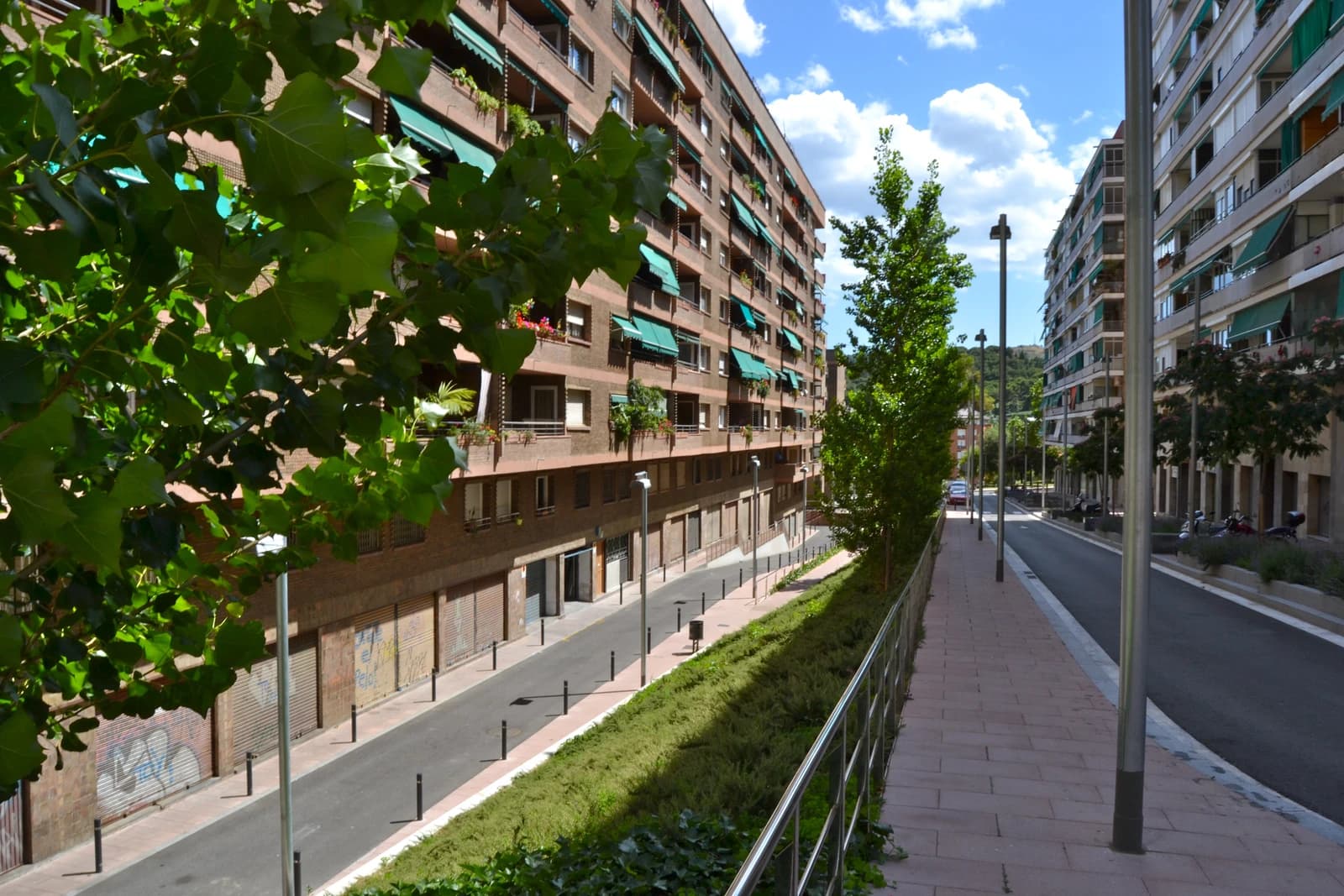 Residential apartment buildings line a street in the Nou Barris district of Barcelona.