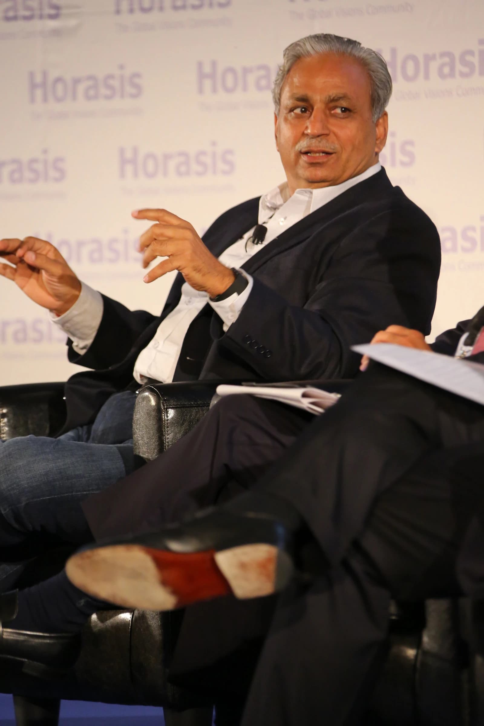 CP Gurnani, CEO of Tech Mahindra, speaking at an event with hands raised.