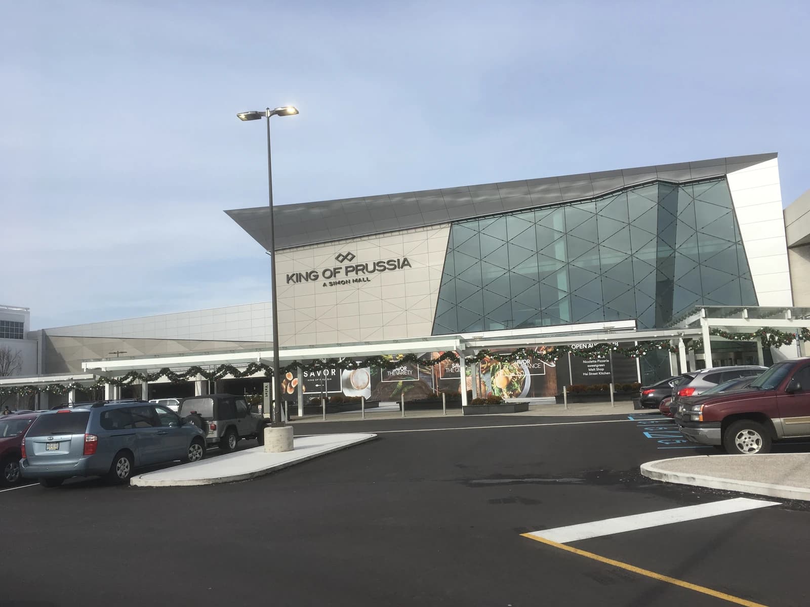 King of Prussia Mall entrance showing part of the building and a parking lot.