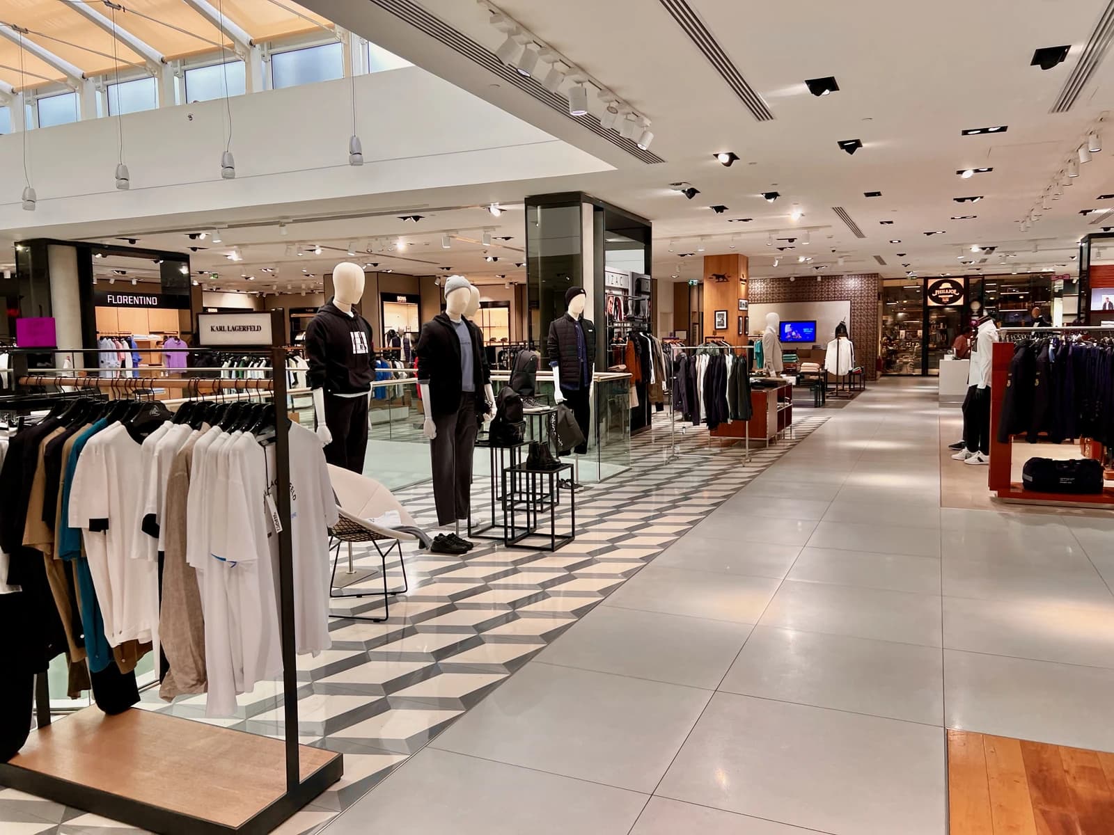 Interior view of a department store with clothing racks and mannequins.