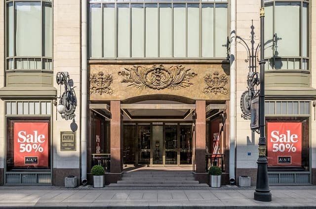 Entrance of DLT Department Store in St. Petersburg with 'Sale 50%' signs.