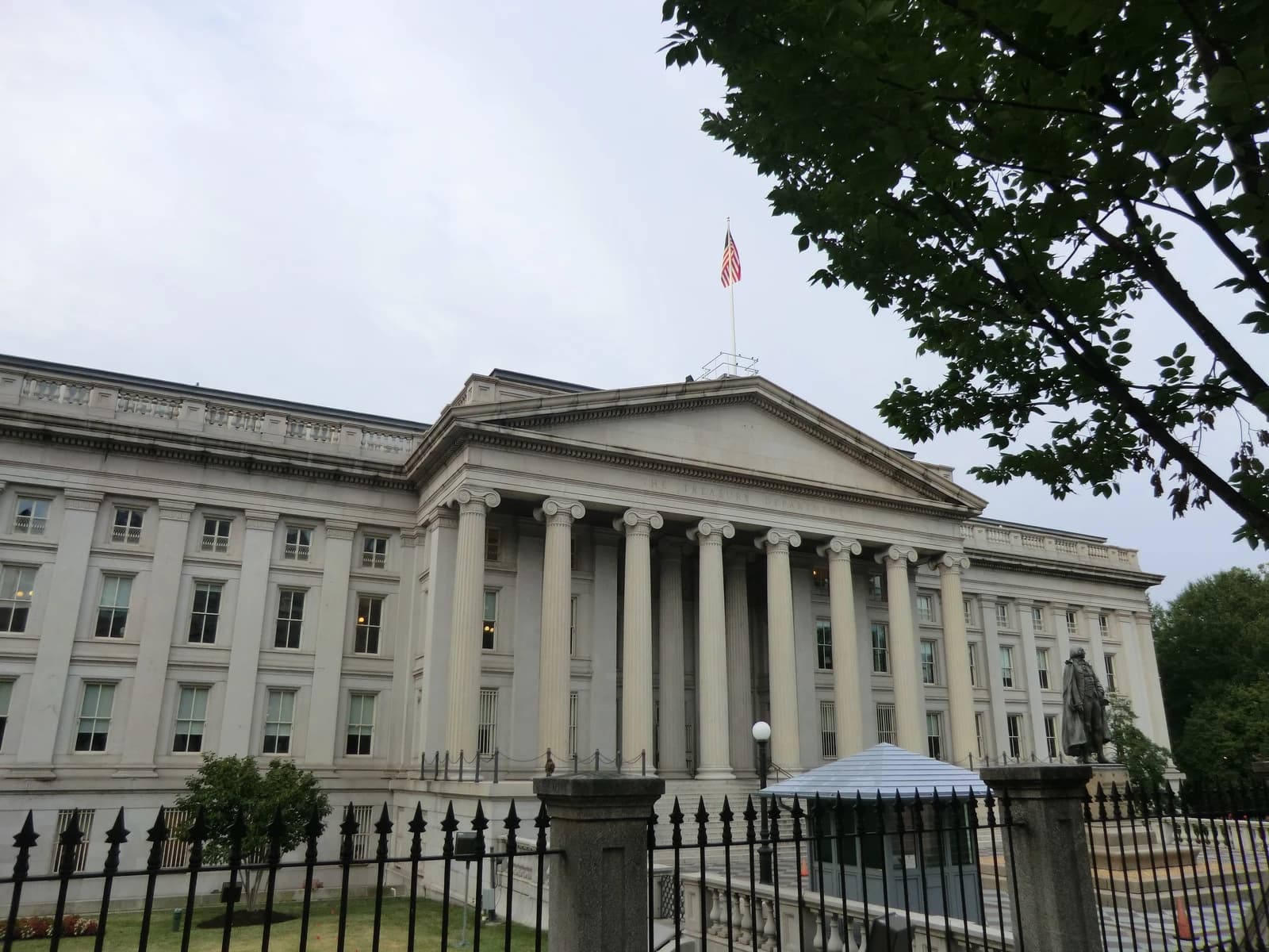 Exterior view of the U.S. Department of Treasury building with flag flying.