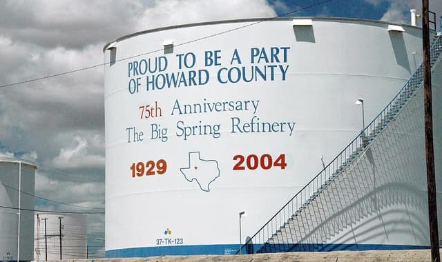 Large white storage tank with text about the Big Spring Refinery anniversary.
