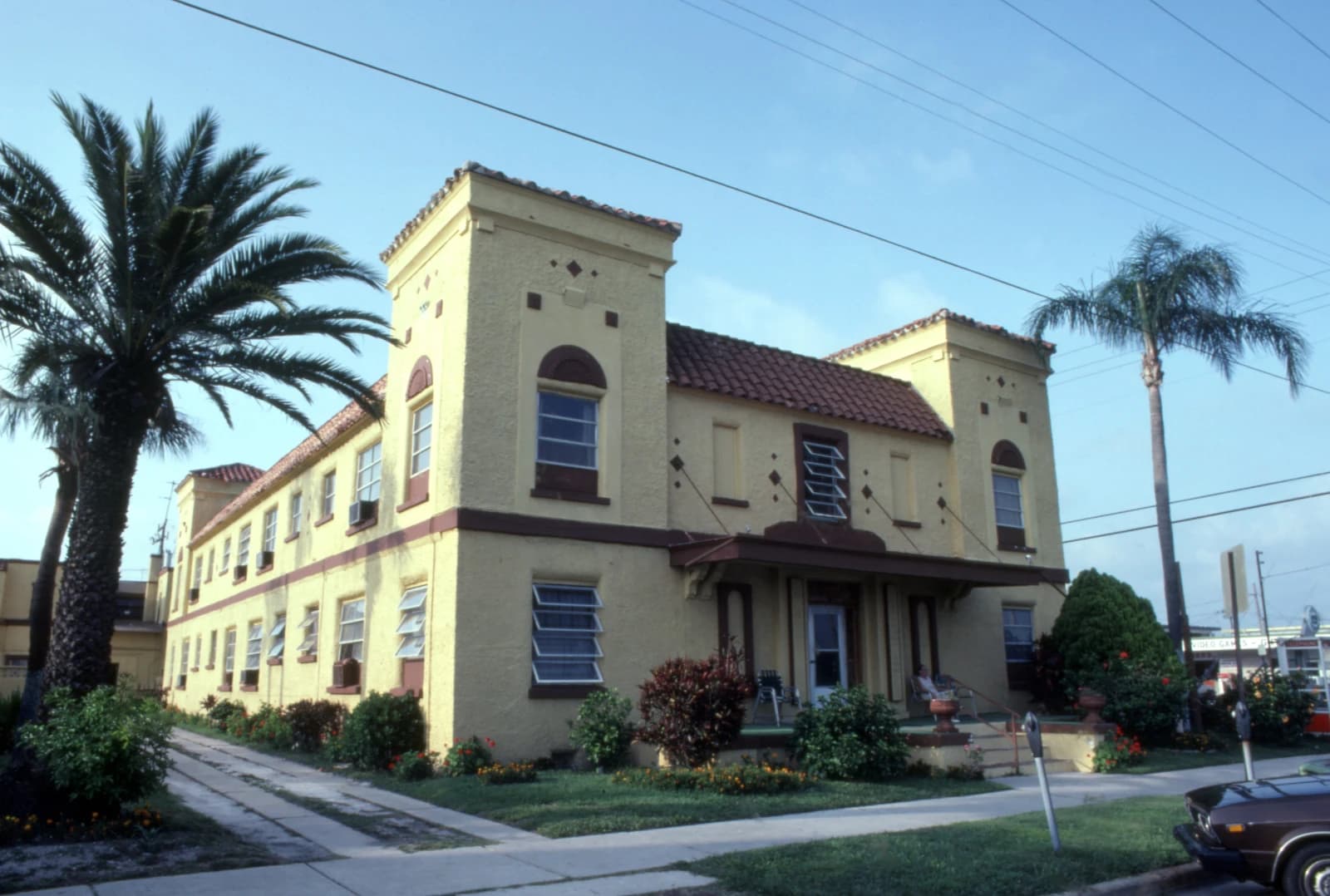 Kipling Arms Apartments building, a yellow Spanish Revival style structure with palm trees.