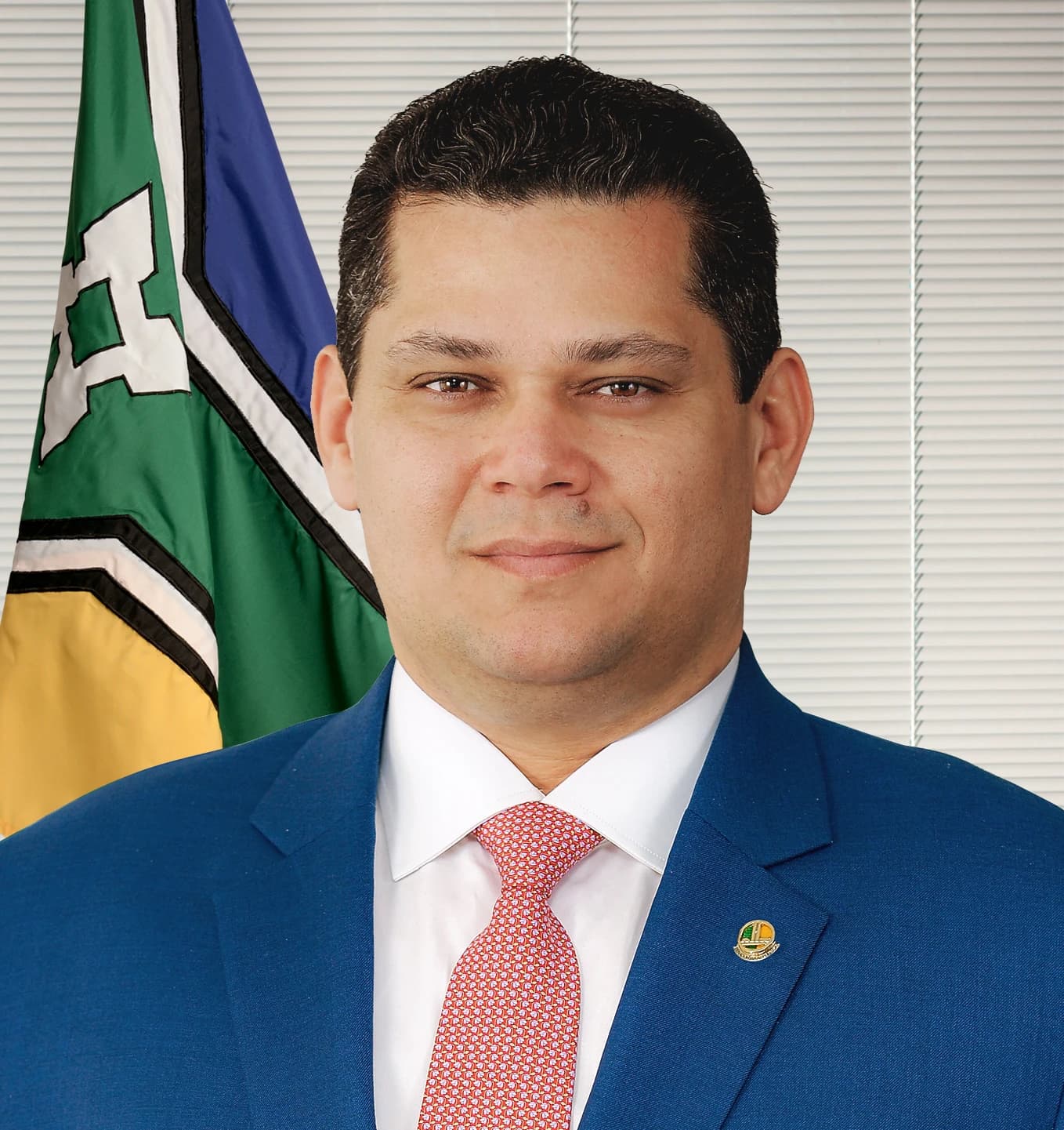 Davi Alcolumbre, Brazilian politician, posing for an official portrait with a flag.