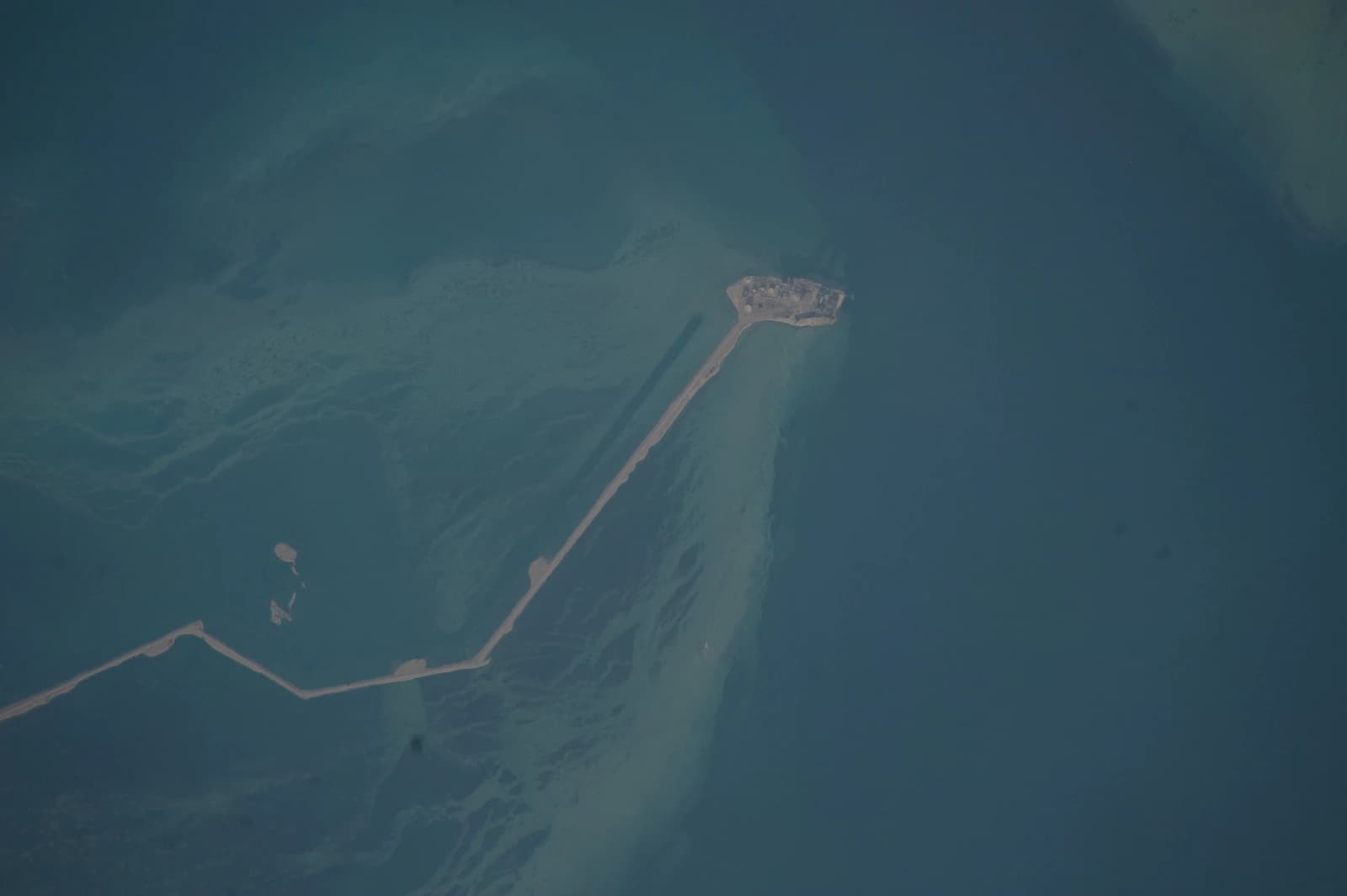 Aerial view of an artificial island with a causeway in the United Arab Emirates.