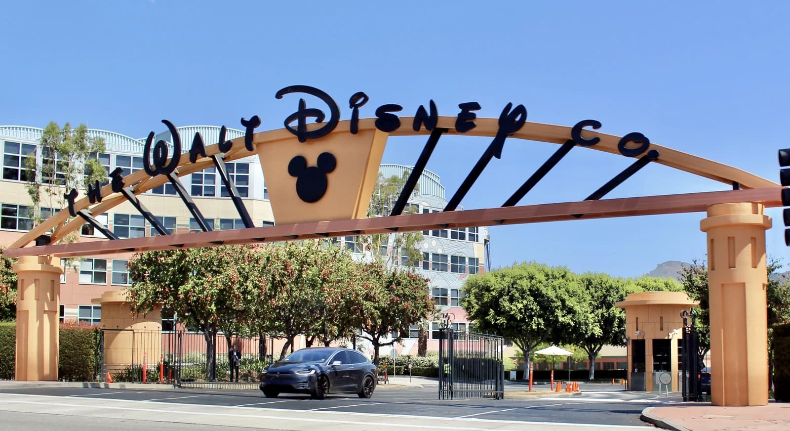 Entrance sign for Walt Disney Studios with the company logo and a car entering.