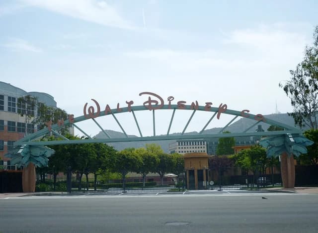 Entrance gate with "The Walt Disney Co." archway leading to studio buildings.